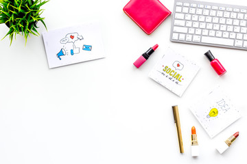 Work desk of beauty blogger with social media icons and cosmetics on white background top view copy space