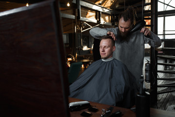 Fototapeta na wymiar Barber cutting hair of customer