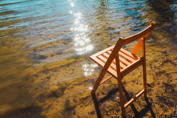 Chair in shallow water of lake