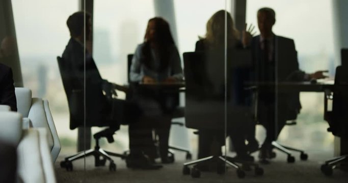 4k, Group of business people having a meeting around a table in an office. Slow motion.