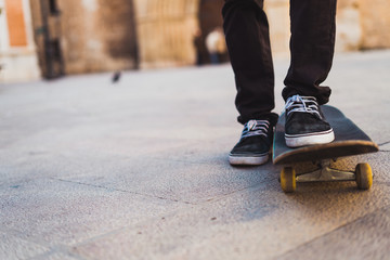 Crop teenage riding skateboard