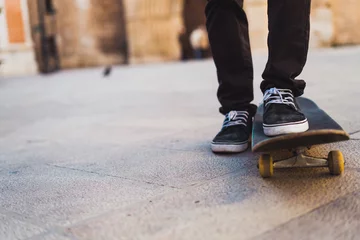 Gordijnen Crop teenage riding skateboard © kikearnaiz