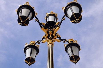 Fototapeta na wymiar Abstract of Artistic and decorative golden and black color royal vintage style four arm lamp post. Madrid Spain.