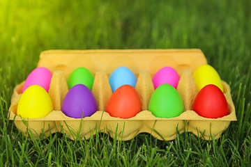 Easter concept. colorful easter bright decorative eggs in a package on green grass. 