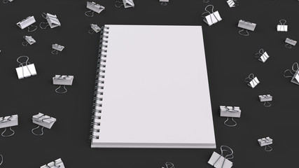 Blank spiral notebook with white binder clips on black table
