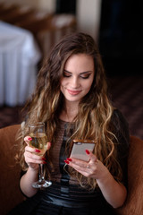 A beautiful girl in a restaurant communicates by phone.
