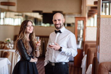 Beautiful couple celebrating and drinking champagne in the restaurant.