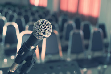 Microphone over the Blurred Chairs in the Conference hall or Seminar Indoor Room Background.