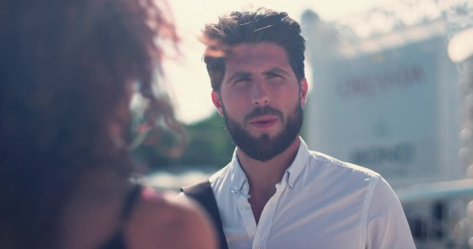 Young attractive man standing on the street talking with woman smiling laughing feel happy close up portrait city male outside love street handsomу shine sun sunset slow motion