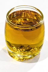 A glass of strong alcoholic beverage on a white background close-up.