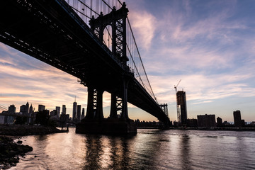 Stunning sunset over the Manhattan bridge and the Manhattan financial district across the East river from Brooklyn in New York City, USA