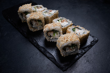 dragon eel sushi rolls in sesame seeds on dark background. Japanese cuisine restaurant menu. Delicious traditional eastern food