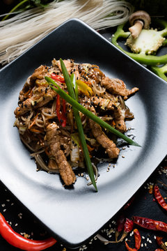 rice noodle pork and vegetable on a plate. traditional asian cuisine food preparing craft