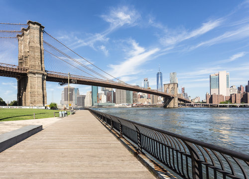 Fototapeta The famous Brooklyn bridge, from DUMBO, with the Manhattan financial district on the other side of the East river in New York city on a sunny day in the USA