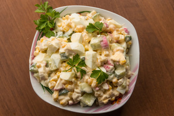 Salad with crab sticks, sweet corn, cucumber, eggs and mayonnaise