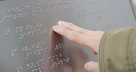 Blind reading on Braille at outdoor directory