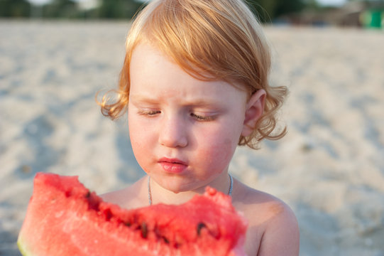 The girl is eating a watermelon and all messed up