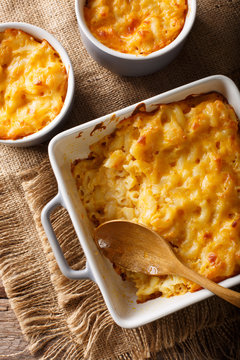 Fototapeta Delicious mac and cheese in a baking dish close-up on a table. Vertical top view