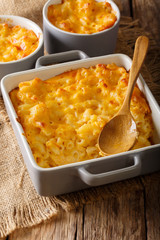 American casserole macaroni and cheese in baking dish close up on the table. vertical
