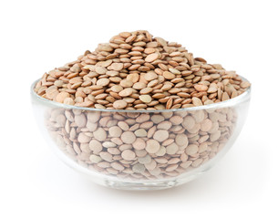 Uncooked lentils in glass bowl isolated on white background with clipping path