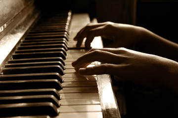 Young girl playing the piano diligently.Cropped shot of a little girl playing the piano.Cropped view of a pianist's hands.
