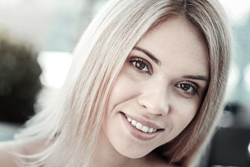 Facial expression. Nice attractive young woman smiling and looking at you while being in a positive mood