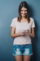 Pretty trendy young woman using a mobile phone