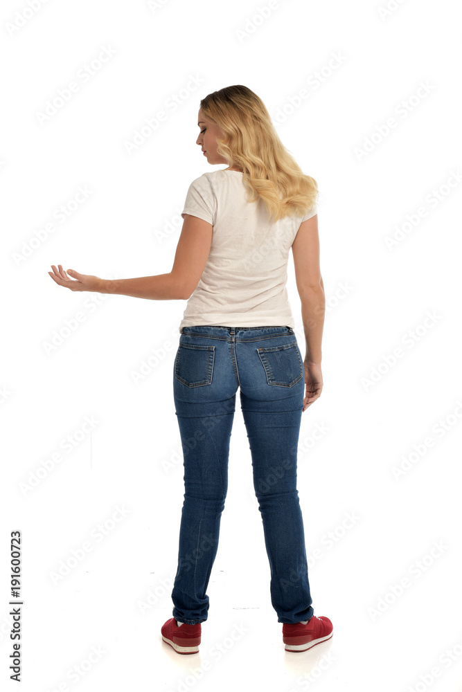 Sticker full length portrait of blonde lady wearing simple white shirt and jeans, standing pose isolated on white studio background.