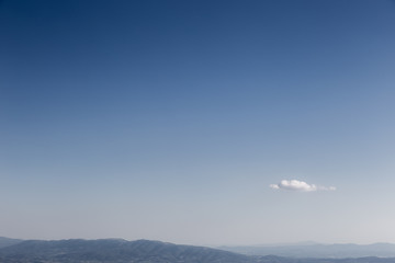 An isolated, little white cloud in an empty blue sky