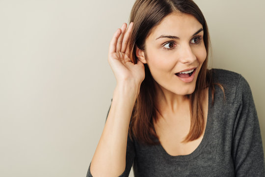 Excited young woman listening to gossip