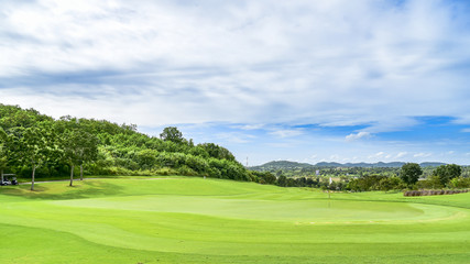 The green grass on golf course with blue cloud sky background
