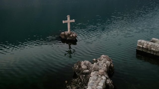 White cross in the sea in City Dobrota in the Bay of Kotor, Montenegro on a sunny day.
