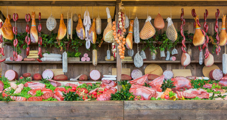fresh food market background with raw pork and vertical assorted salami sausages.