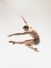The male athletic ballet dancer performing dance isolated on white background.