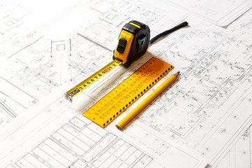 yellow ruler, yellow pencil and a collapsible ruler on architecture blueprint plan