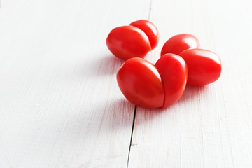 Cherry tomatoes shaped of heart, Valentines day and love theme. Copy space.