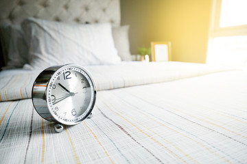 modern and comfortable in bedroom with pillow, clock and sunlight from window, warming process style
