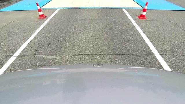 A car changes its direction when it drives on a slippery road in a safe driving center. Close-up shot.