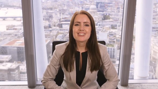 4K Happy successful businesswoman making video call in corporate office with city view in background
