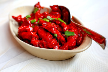 raw chicken wings marinated with honey, soy sauce,spices sprinkled with finely chopped parsley in oval baking pan prepared for roast, asian recipe, view from above, close-up