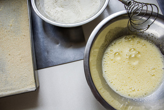 Bowls with beaten eggs and flour