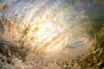 Golden sunset colours reflecting off a breaking wave