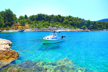 Fototapeta na wymiar Boat fixed on rocky beach, beautiful blue sea, Island Hvar, Croatia