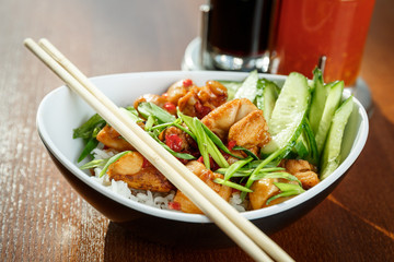 Asian riсe with chicken and vegetables in oval plate with bamboo sticks