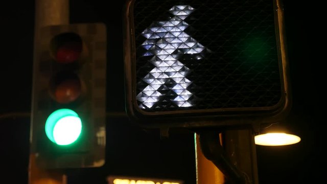 Crosswalk signal illuminated at night in city