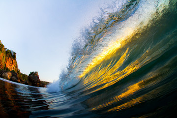 golden wave crashing at sunset in the ocean