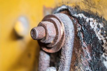 rusty srew and nut closeup connected with rusted chain -