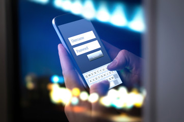 Login with smartphone to online bank account or personal information on internet at night. Hands...