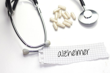 alzheimer text on paper and stethoscope and white medicament 