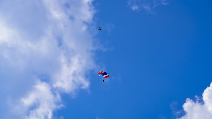 Naklejka na ściany i meble Skydriver jumping with parachut with blue cloud sky background